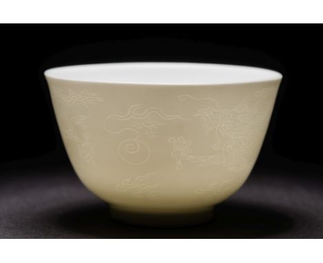 A Chinese porcelain bowl: of finely potted circular form with Anhua decoration, the white body incised with a pair of dragons