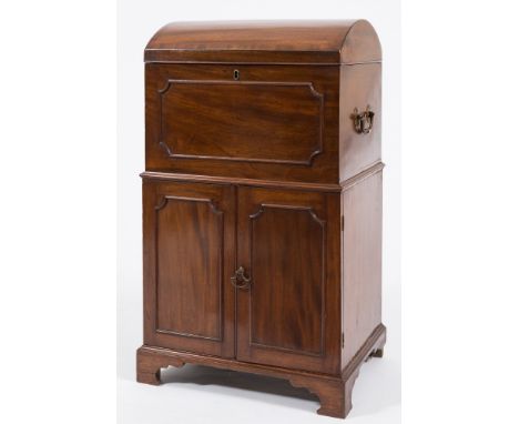 An early 19th Century mahogany domed trunk-shaped cellarette cabinet:, the crossbanded hinged top enclosing a fitted and baiz