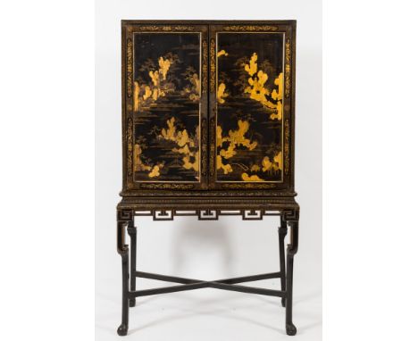 An early 19th Century Chinese black lacquer and gilt heightened cabinet on stand:, the architectural interior fitted with sma