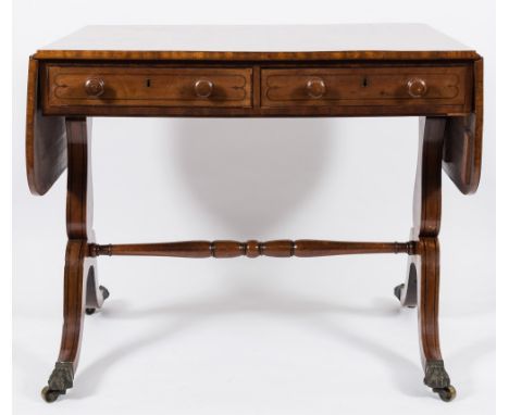 A Regency mahogany and inlaid sofa table:, bordered with ebonised lines, the hinged top with a wide rosewood cross banded bor