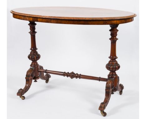 A Victorian carved walnut oval centre table:, the burr quarter veneered top with a moulded edge, on turned and reeded knopped