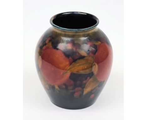 A Moorcroft pottery vase: of oviform tubelined in the Pomegranate pattern in red, orange, purple and green on a graduating bl