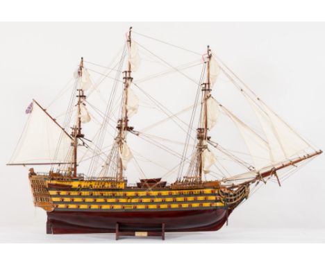 A scale model of HMS Victory:, fully rigged over detailed decks with cannon, lifeboats, carved figurehead, open gun ports wit