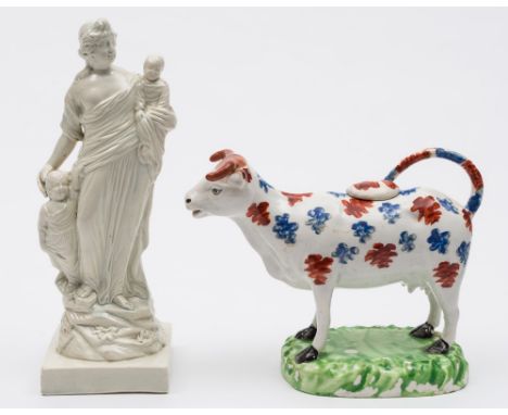 A Cambrian pottery cow creamer and a Ralph Wood type figure: the former modelled standing four square with raised tail on a r
