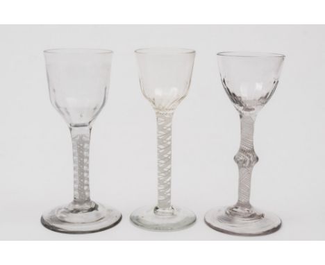 Three various opaque twist wine glasses: two with ogee shaped bowls with basal fluting set on straight stems with a central p