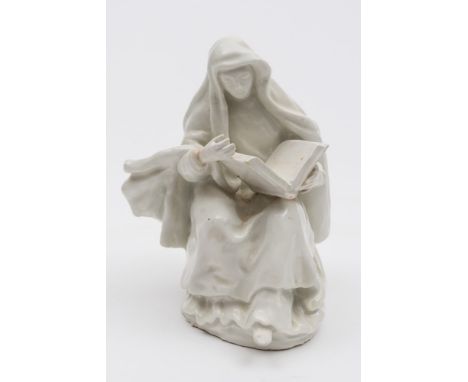 An early Bow white figure of a seated nun: wearing a hooded cloak over elaborate robes and reading from a Bible, circa 1755/6