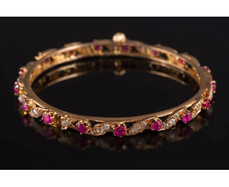 A ruby and diamond mounted hinged bangle: with round rubies separated by diamond-set scrolls and with screw clasp.