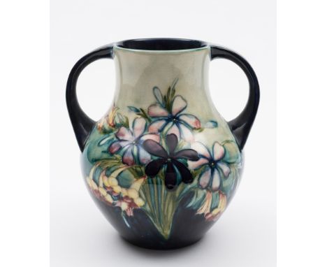 A Moorcroft pottery vase: of pear shaped two handled form, tubelined in the Spring Flowers pattern in light and dark blue, ye