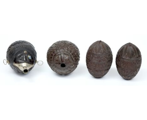 A mid 19th century carved coconut 'Bugbear' flask and three unmounted flasks: the first finely carved overall with a colonial