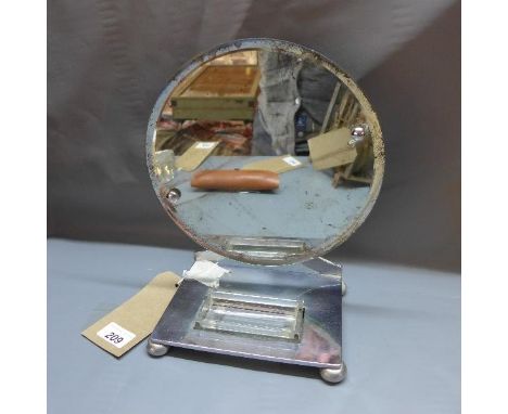 An Art Deco chrome vanity mirror, with round bevelled glass plate and glass dish on rectangular base, raised on bun feet, H.2