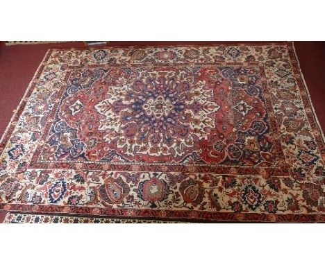 A fine North West Persian Bakhtiar carpet with central floral medallion on a terracotta field within stylised ivory floral bo