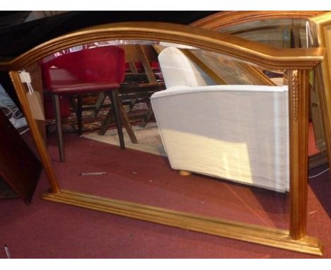 A contemporary gilt overmantel mirror, with arched pedestal top, floral decorated supports, bevelled glass plate, on stepped 