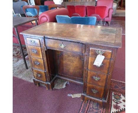 A Queen Anne style burr walnut kneehole desk, with nine drawers and one central cupboard door, raised on bracket feet, H.76 W