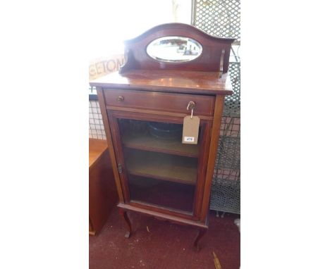 An Edwardian mahogany music cabinet, with oval mirror back plate, above one drawer and one glazed door, raised on cabriole le