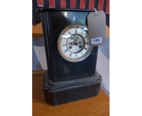 A late 19th century black slate mantel clock, drum movement, striking a bell, the white enamel Roman dial with visible Brocot
