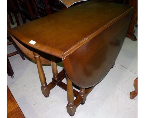 An Ercol style oak oval drop leaf dining table and 4 wheel back chairs