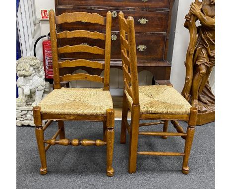 A good set of twelve reproduction Belvedere Furniture light oak ladderback dining chairs with drop in rush seats.
