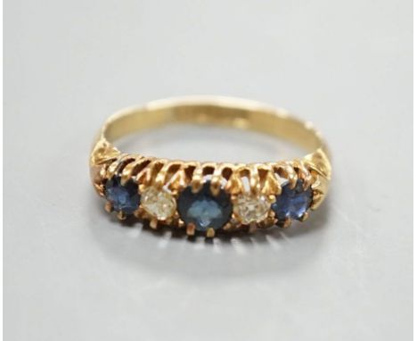 A George V 18ct gold, three stone sapphire and two diamond set half hoop ring, size M, gross 3.1 grams.