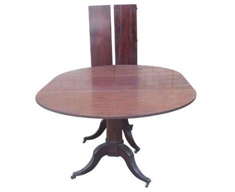 A George III three pillar dining table, the reeded top having two D ends, with ebony stringing, septagonal taper pillars, eac