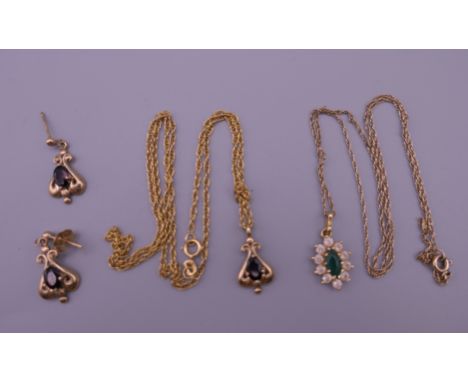 A 9 ct gold garnet set pendant on a 9 K chain with a pair of matching earrings and another pendant on a 9 ct gold chain. 7.8 
