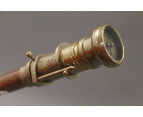 A walking stick topped with a telescope and compass. 97.5 cm long.