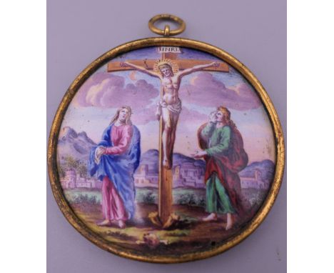 An antique Limoges enamel pendant depicting the crucifixion of Christ. 5 cm wide.