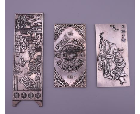 Three Chinese white metal scroll weights. The largest 14.5 cm long.