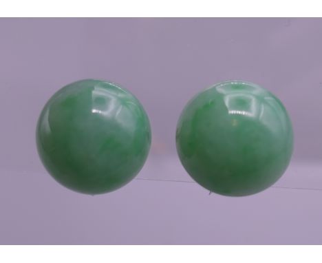 A pair of 9 ct white gold apple green jade cabochon earrings. 1.25 cm diameter.