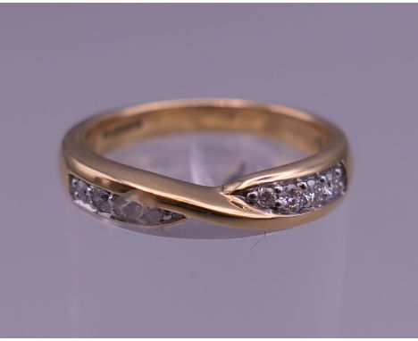An 18 ct gold diamond cross over ring. Ring size K. 4.2 grammes total weight.