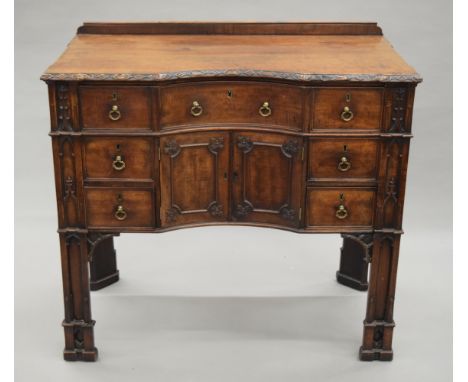 A 19th century Gothic revival mahogany dressing/writing table, with Gothic architectural designs, the top drawer fitted with 