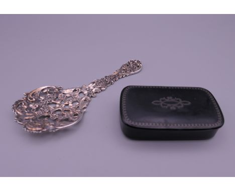 A pierced silver spoon and a papier mache snuff box. The former 12 cm long.