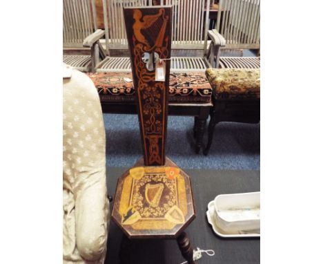 An Edwardian Irish spinning chair inlaid with harps, shamrocks, crested shields and Celtic motif's raised on four ring turned