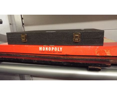 A vintage shove ha'penny board together with a cased backgammon set and monopoly game