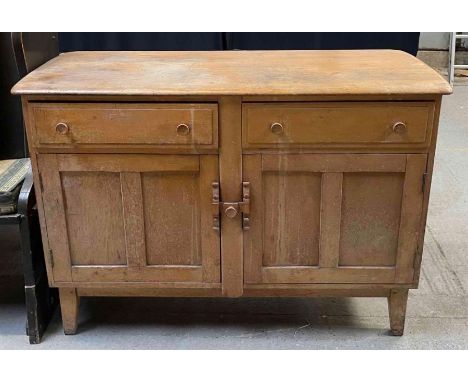 An Ercol century light wood sideboard fitted with drawers and cupboards, black and gold applied label to the inside of one do