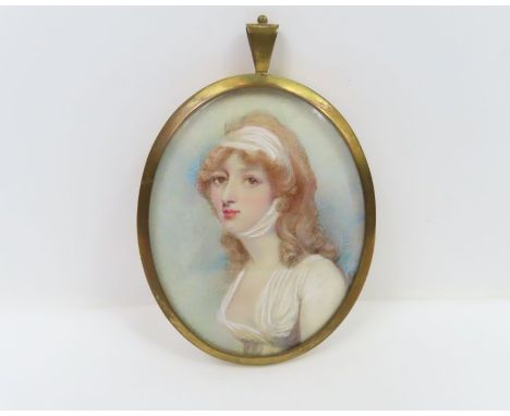 An oval miniature portrait on ivory of a young woman in Regency style dress with a scarf in her hair, in gold metal pendant f