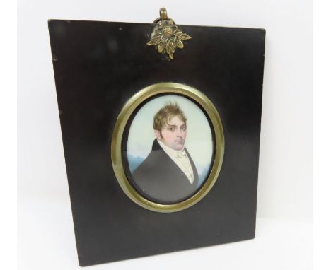 An oval miniature portrait on ivory of an 18th century gentleman, in black frame with floral hanger, miniature 6.5cm x 5.25cm