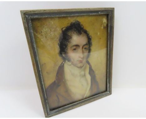 An 18th century miniature portrait on ivory of a "Romantic" gentleman wearing a light brown jacket, in white metal frame, 8cm