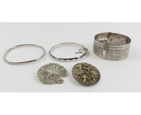 A silver hinged bangle, another bangle, a wide decorative bangle with buckle style fastening, both testing as sterling silver