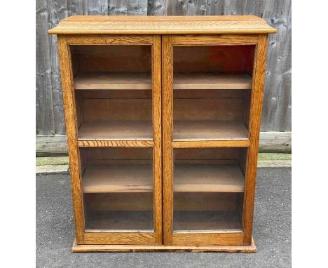 An early 20th century light oak bookcase fitted with three shelves 101cm high 82cm wide 28cm deep