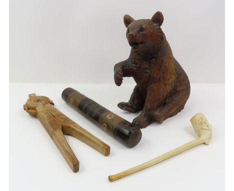 A Black Forest carved wood bear, with black glass inset eyes, 18cm high; a Scandinavian carved wood nutcracker; a clay pipe a