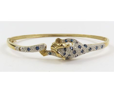 A sapphire and diamond set hinged bangle, the front in the form of a leopard, marked 'DIA 0.10' to the inside, internal diame