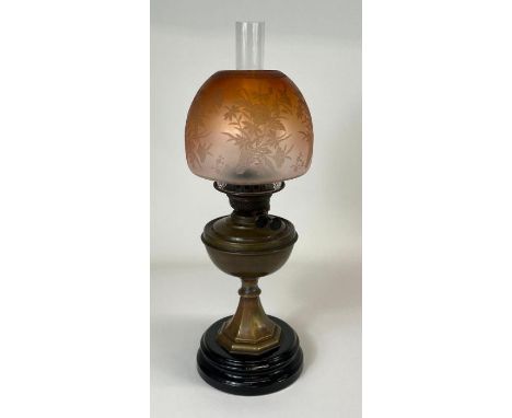 A late 19th/early 20th century oil lamp having brass base and etched amber glass shade, height 56cm max