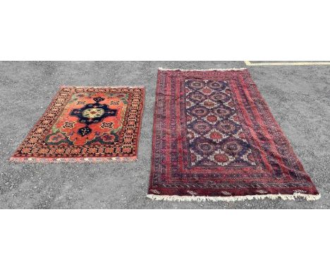 A Middle Eastern wool rug in light red/blue/green having central medallion with geometric borders, 170cm x 125cm, together wi