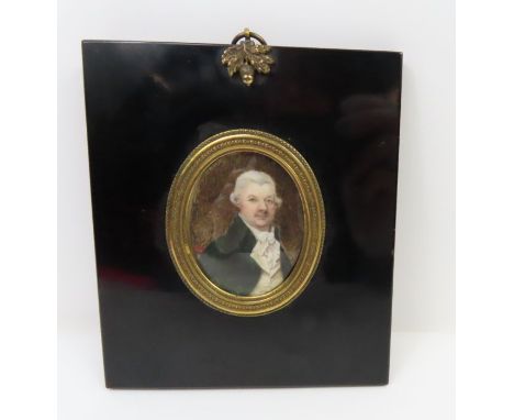 A late 18th century oval portrait miniature on ivory of a gentleman wearing wig and high collared jacket, in black frame with