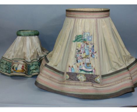 Two similar Chinese silk lamp shades, the largest decorated with panels of battle scenes, the other with female characters in