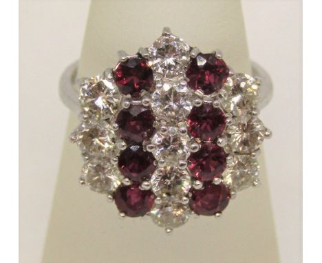 Impressive 18ct white gold ruby and diamond cluster ring, set with nineteen round cut stones, size N, 5.3g