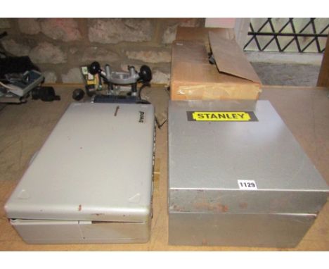 A Stanley steel cased model 1287 1.5hp heavy duty plunge router and TP/SA7 router guide, together with a further steel cased 