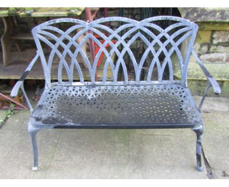 A contemporary cast aluminium two seat garden bench, with pierced Gothic tracery pattern back and further pierced seat, raise