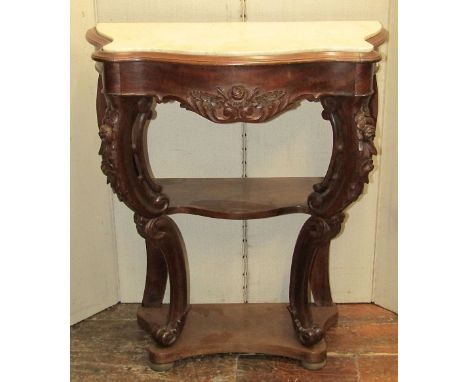 A mid-19th century mahogany console table of serpentine form raised on pierced and scrolled supports and three tiers, set ben