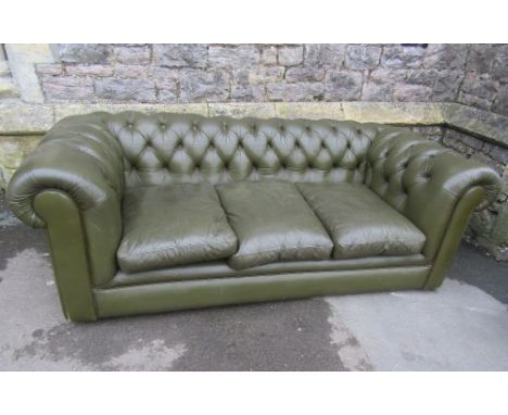 A traditional green leather upholstered three seat Chesterfield sofa, with button back, rolled arms and loose feather filled 